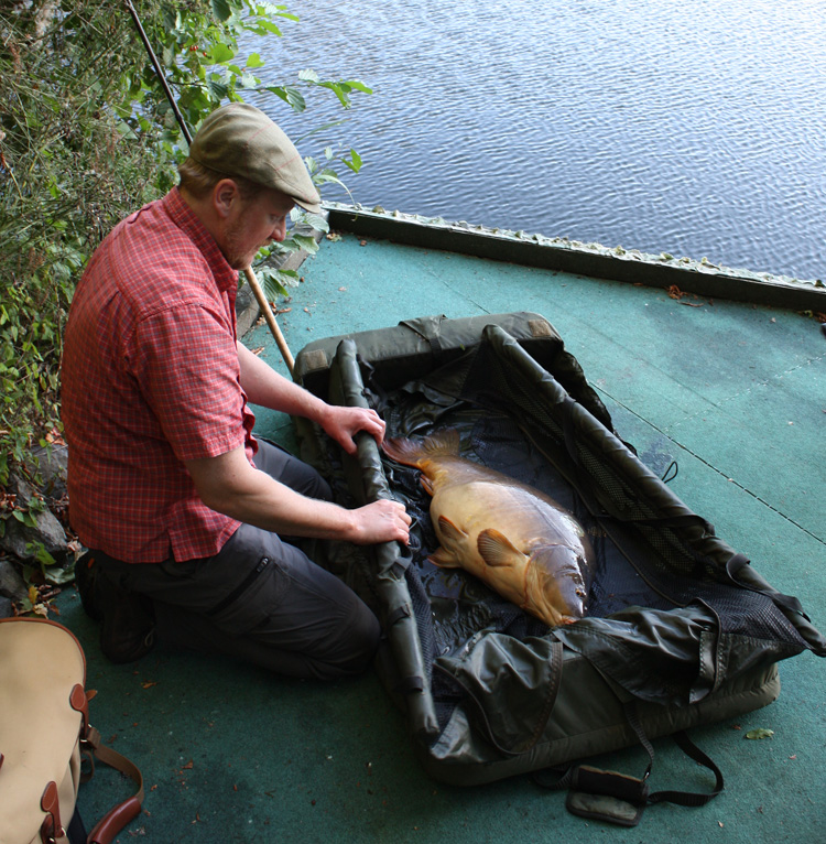 Preparing to pose with a carp at Quarry Bank Fishery, France